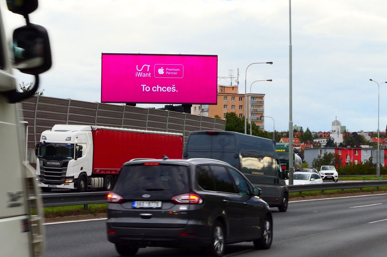 Kampaň iWant na LED obrazovce nad městskou dálnicí, zachycená z projíždějícího vozu