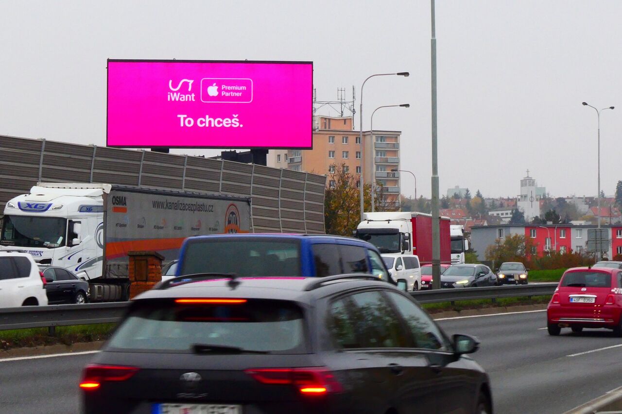 Kampaň iWant na LED obrazovce nad dálnicí s kamiony a osobními auty
